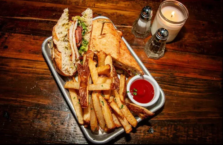 A toasted sandwich and chips on a tray at The Canary